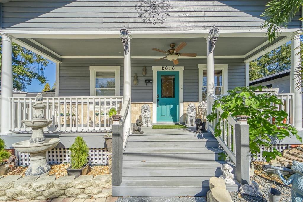 ein Haus mit einer blauen Tür und einer Veranda mit einem Ventilator in der Unterkunft Tampa Ybor Bungalow in Tampa