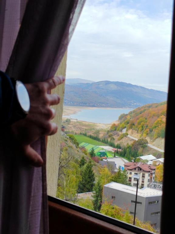 a person looking out of a window at a lake at Moun2 in Mavrovo