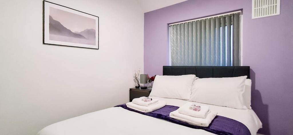 ein Schlafzimmer mit einem Bett mit zwei Handtüchern darauf in der Unterkunft Charming 3-Bedroom Home Near NEC, Birmingham Airport & Bullring in Birmingham