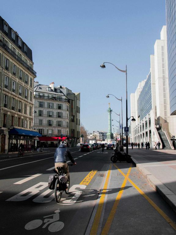 une personne à vélo dans une rue de la ville dans l'établissement Résidence Antoine - 2P ou 4P -Bastille, à Paris