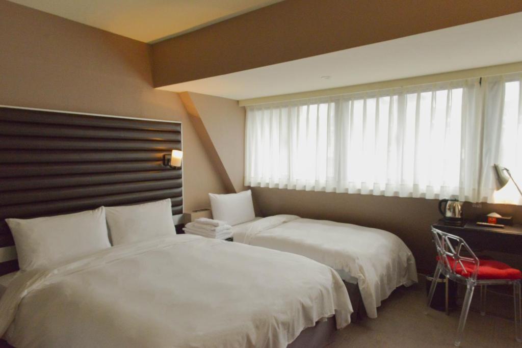 Postel nebo postele na pokoji v ubytování 新麗旅店 Newful Hotel