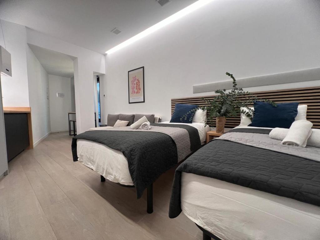 a bedroom with two beds with blue and white pillows at Sorolla Urban Suites in Valencia