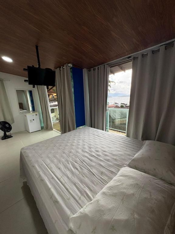 a bedroom with a large bed and a large window at Casa Panorâmica in Angra dos Reis