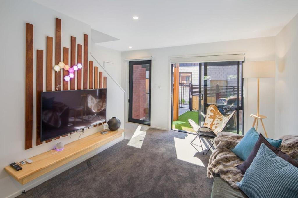 a living room with a large flat screen tv at It's Gettin' HUT in Here in Lower Hutt