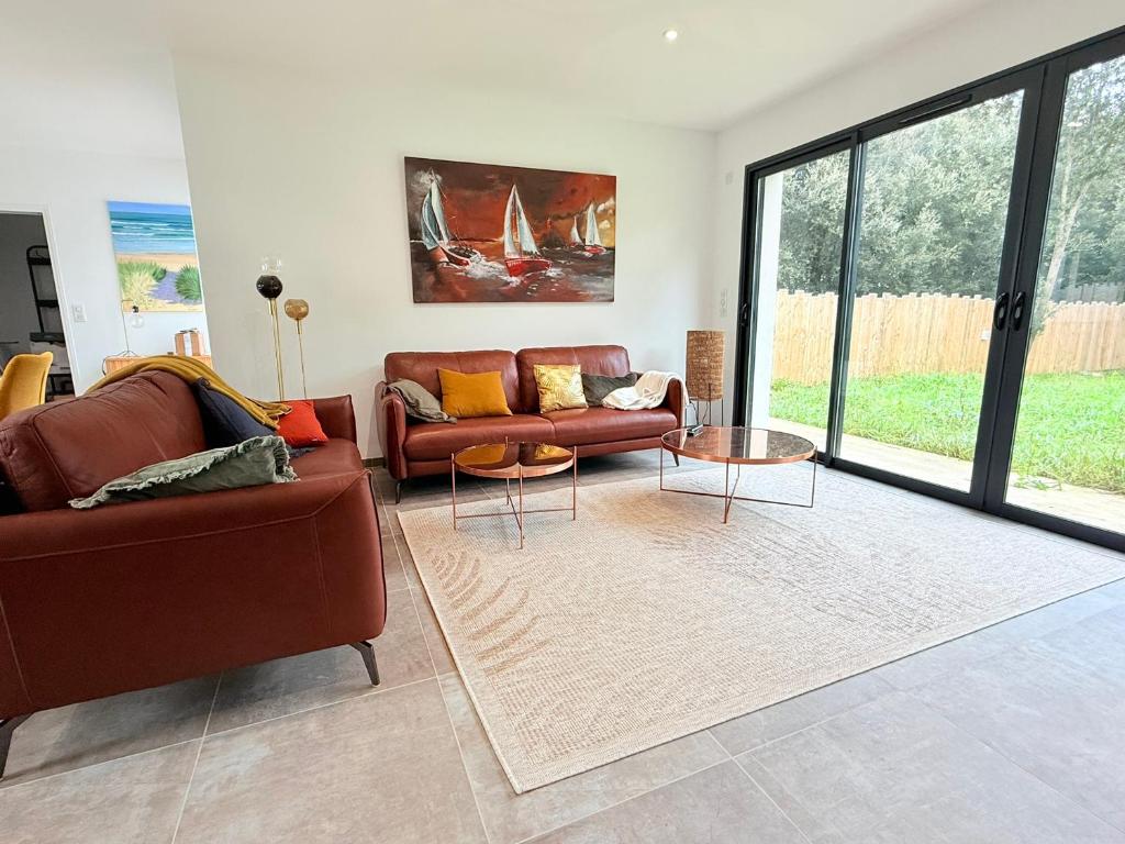 un salon avec deux canapés et une table dans l'établissement Maison neuve 3 chambres, proche plage, grand jardin - FR-1-778-37, à Saint-Pierre-dʼOléron