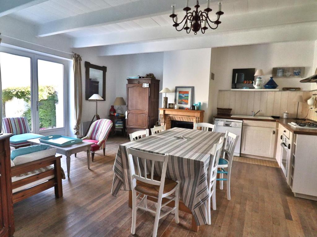 une cuisine et un salon avec une table et des chaises dans l'établissement Charmante Maison 8 pers. à 500m de la plage avec Jardin & BBQ - FR-1-813-16, à Groix
