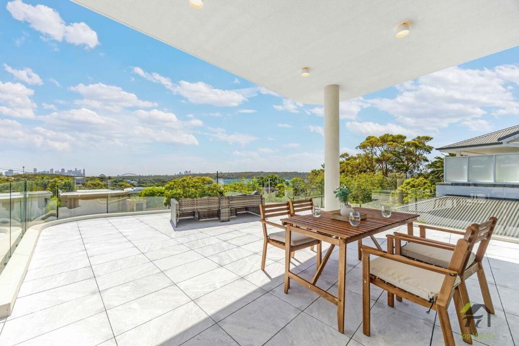 an outdoor patio with a wooden table and chairs at Harbour view new year firework in Sydney