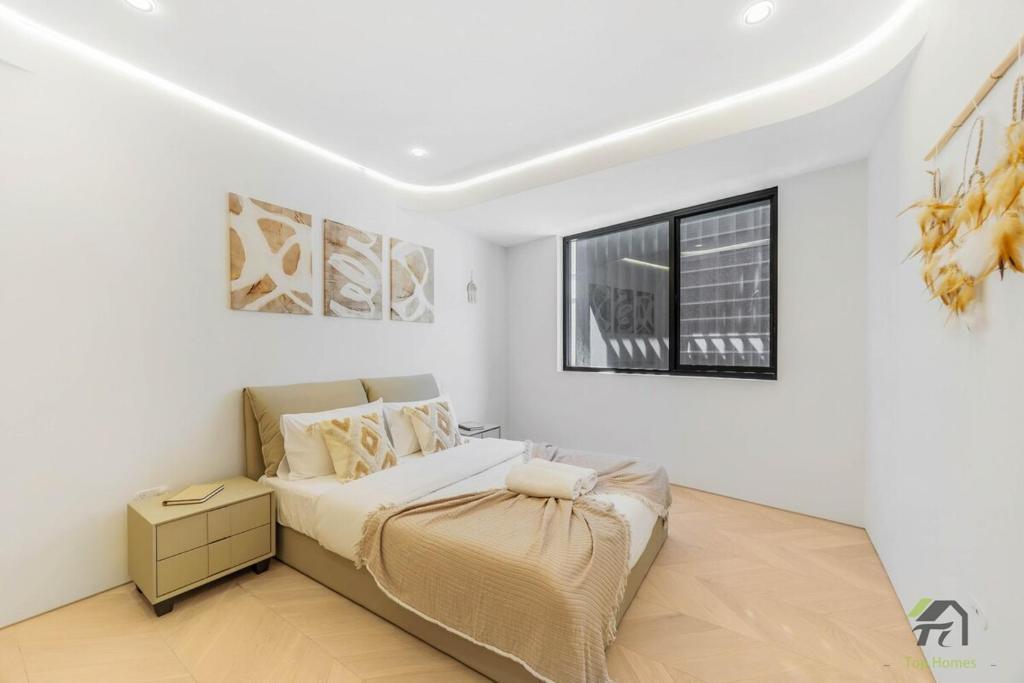 a white bedroom with a bed and a window at Harbour view new year firework in Sydney
