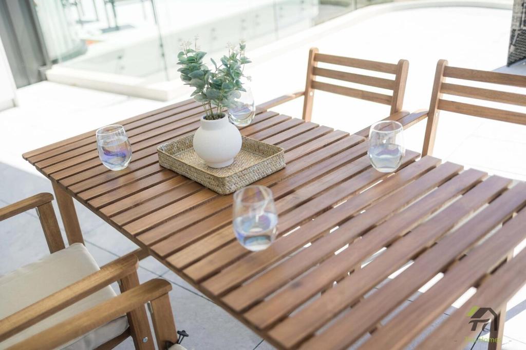 a wooden table with a vase and glasses on it at Harbour view new year firework in Sydney