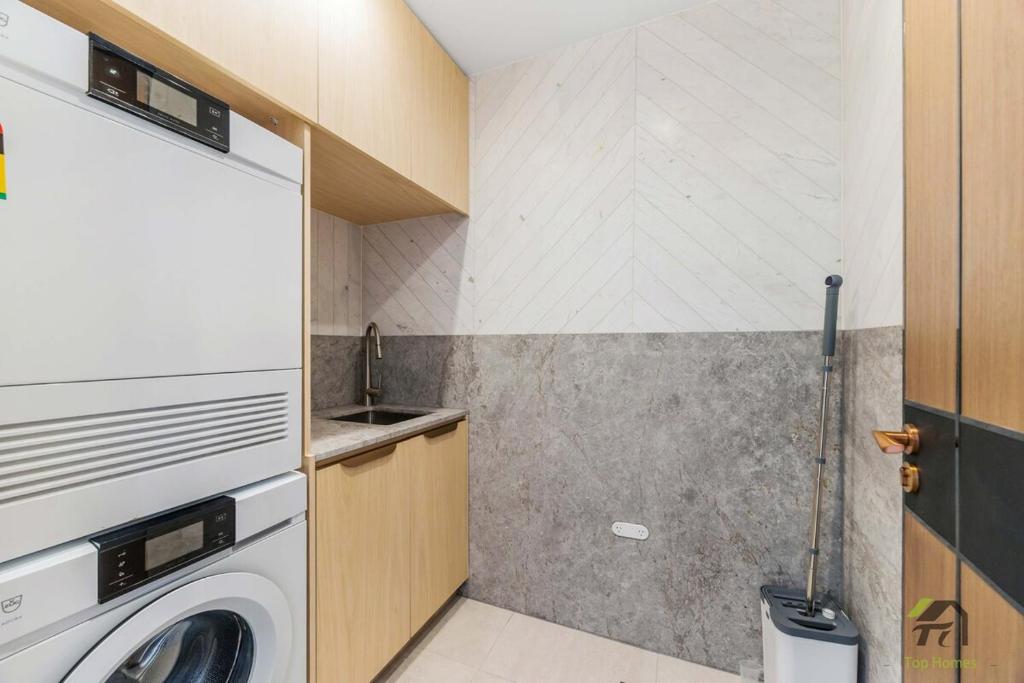 a laundry room with a washer and a sink at Harbour view new year firework in Sydney