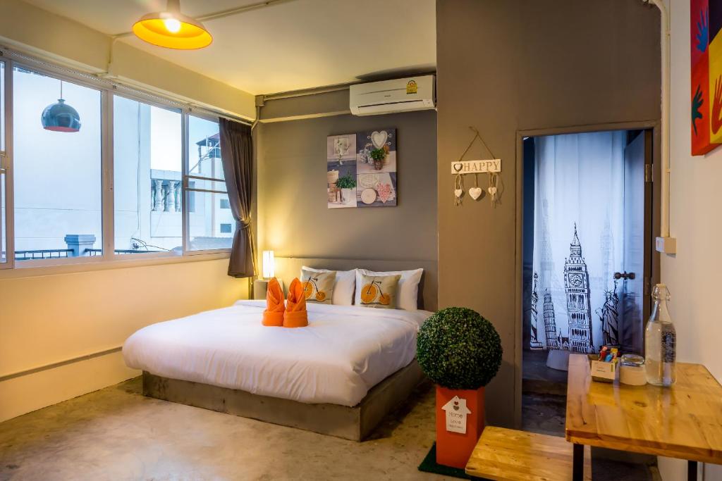 um quarto com uma cama com almofadas laranja em Love CNX Guesthouse em Chiang Mai