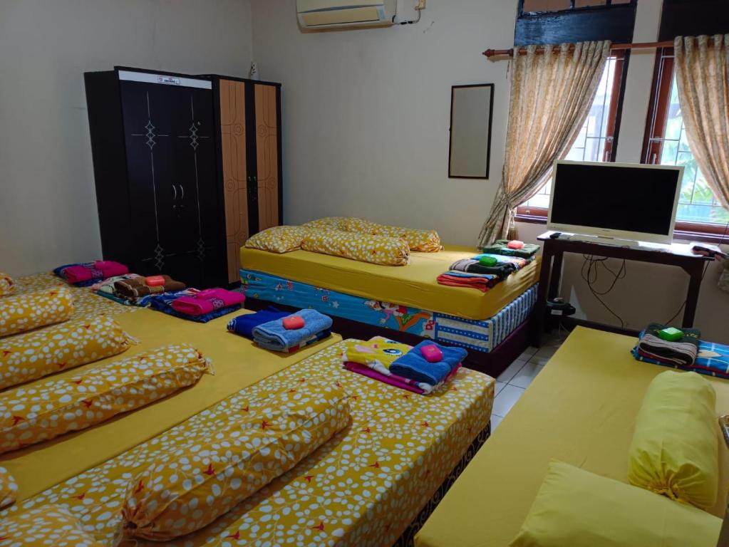 a room with four mattresses and two beds at Ray Executive Guesthouse Rooms in Jakarta