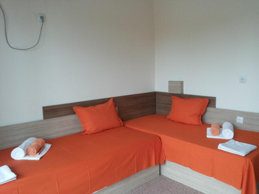 a bed with orange sheets and orange pillows at Family Hotel Golden Lion in Primorsko