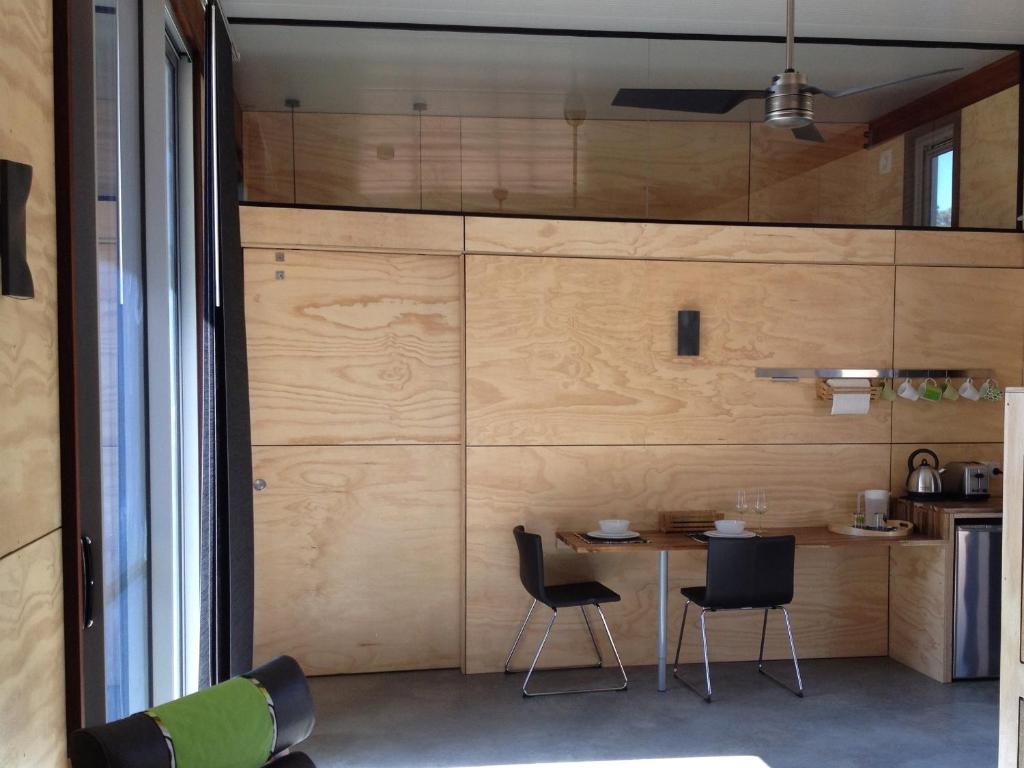 ヤリンガップにあるBed + Bauhausのテーブルと椅子2脚が備わる壁の客室です。