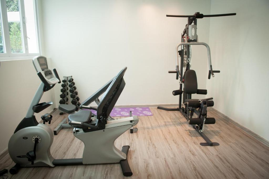 A compact fitness room with cardio equipment, dumbbells and a multi-gym.
