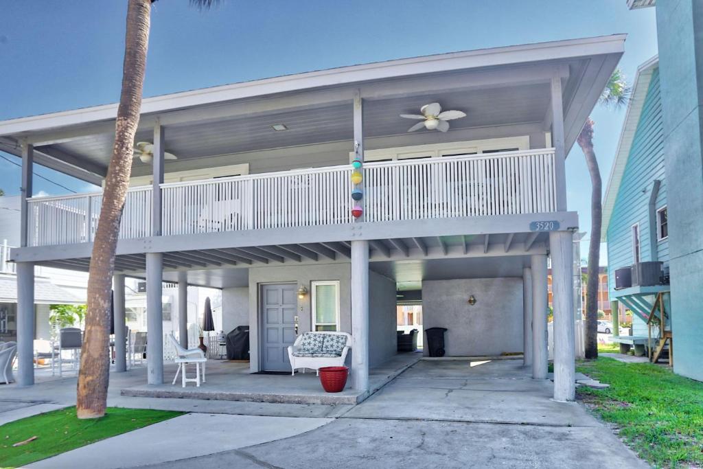 een huis met een balkon en een veranda bij Valdes Cottage in St Pete Beach