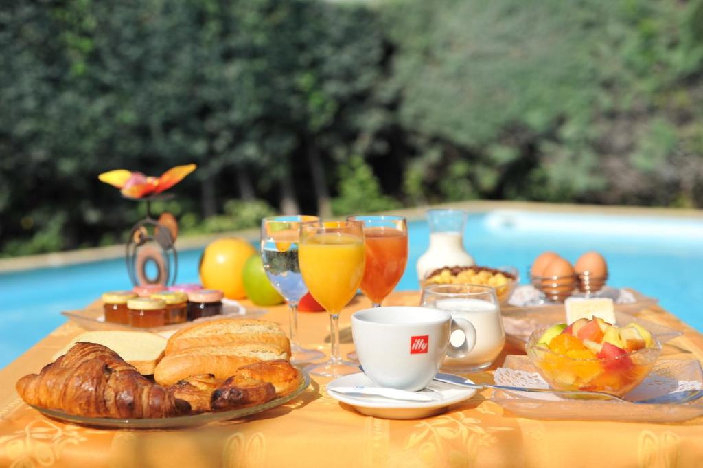 a table with breakfast foods and drinks on it at Hôtel Belvedère Cannes Mougins in Mougins