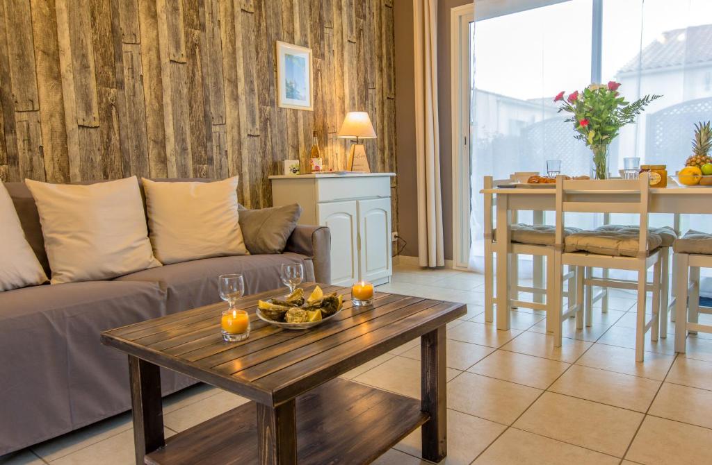 Atlantic Residence في جونزاك: غرفة معيشة مع أريكة وطاولة مع برتقال عليها