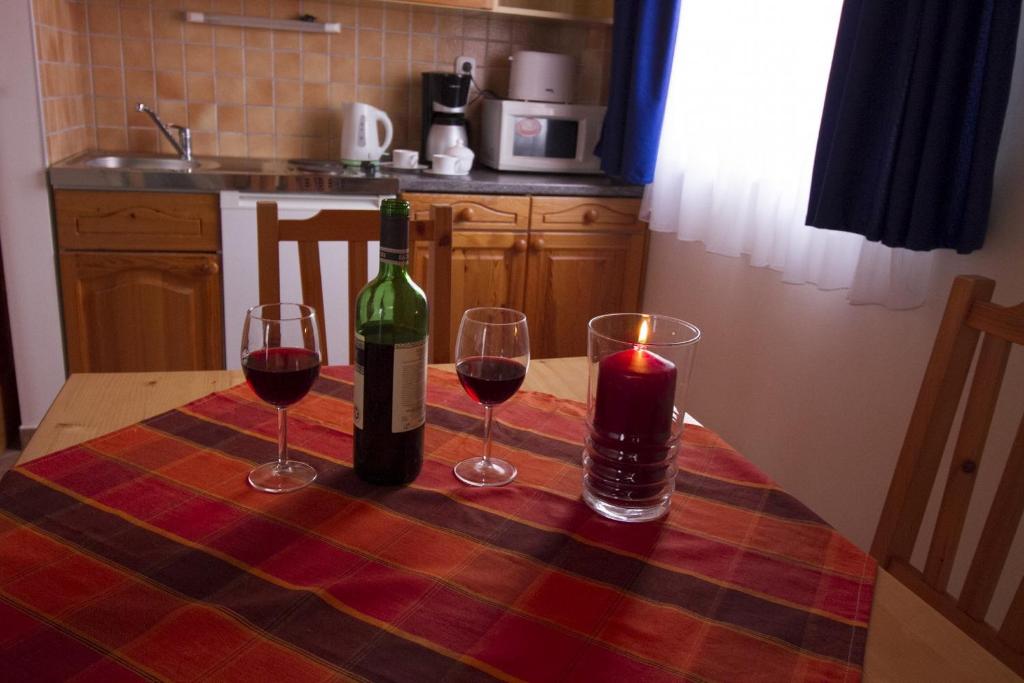 ザラカロシュにあるRelax Apartment Houseのワイン2杯とキャンドル付きテーブル