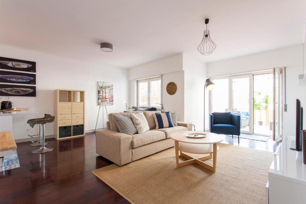 a living room with a couch and a table at JOIVY Superb 1-bed Apt with workspace and terrace, close to Avenida da Liberdade in Lisbon