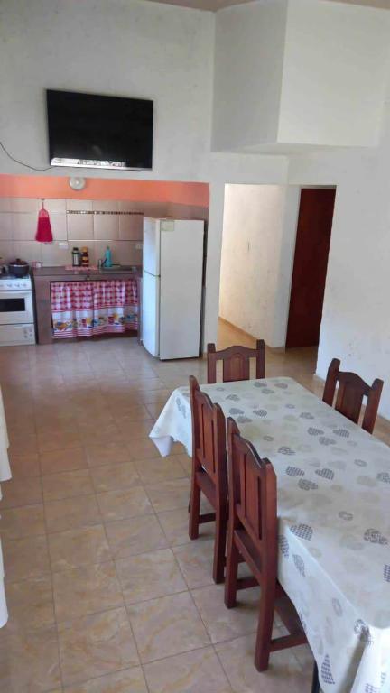 a dining room with a table and chairs and a kitchen at Happy House in Tanti