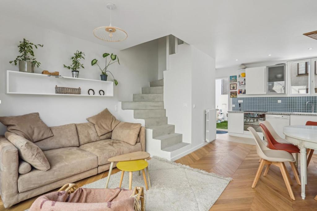 un salon avec un canapé et une table dans l'établissement Family home, à Romainville