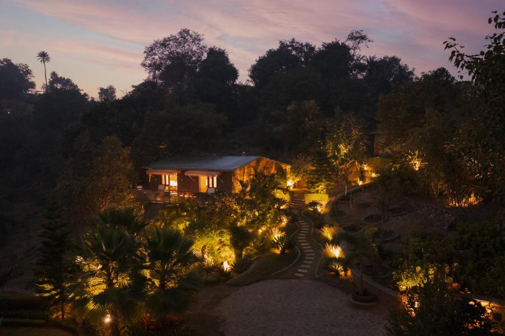 an aerial view of a house at night with lights at SaffronStays Sylvan Farms - 3BR eco-luxury villa with birdwatching, trekking and organic farming in Mount Abu in Delmāra