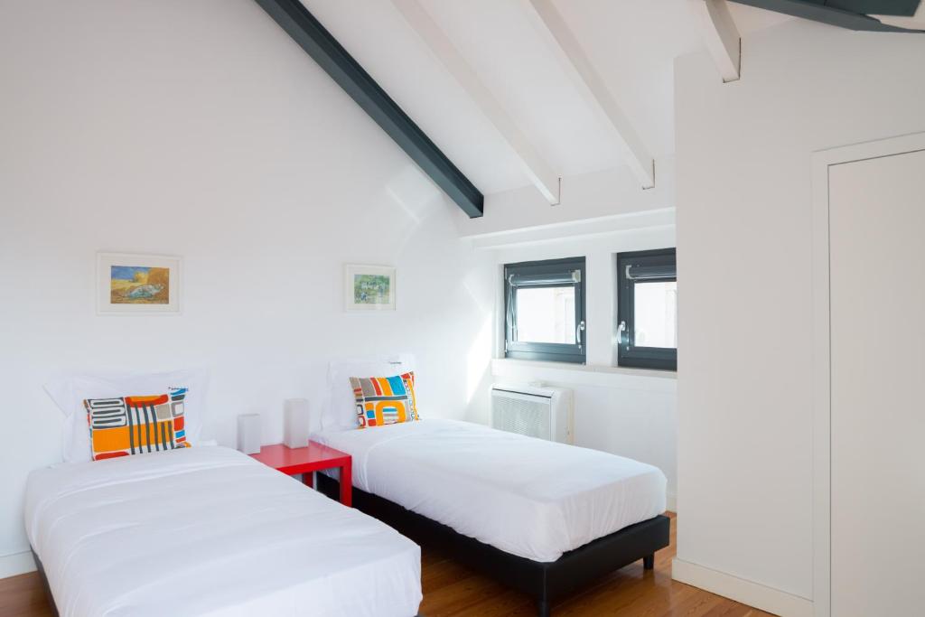 2 Betten in einem Zimmer mit weißen Wänden in der Unterkunft FLH Bairro Alto Luxus Flat in Lissabon