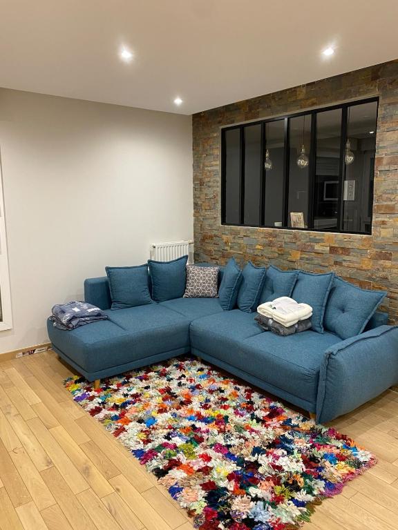 - un canapé bleu dans le salon avec un tapis dans l'établissement Beautiful 2 rooms, near Paris, à Rueil-Malmaison