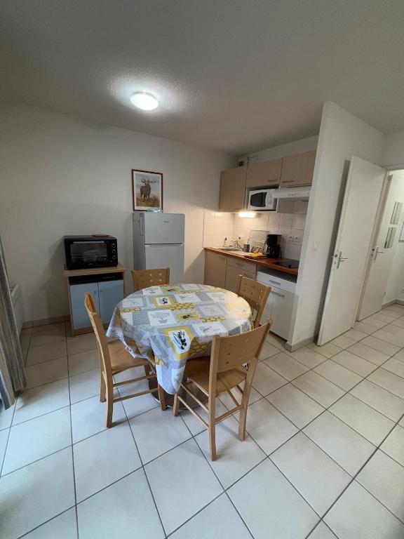 une cuisine avec une table et des chaises dans une pièce dans l'établissement Balcons de la Neste Arreau C, à Arreau