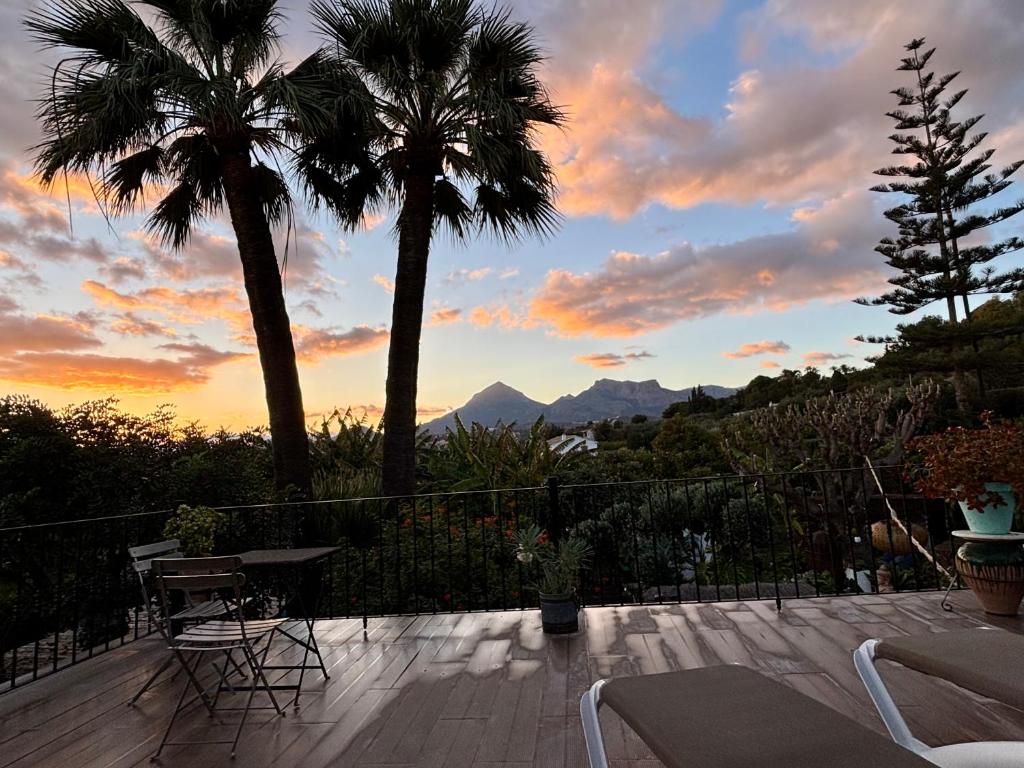 a patio with a table and palm trees at sunset at Hotel Altea Paradise 1917 - Adults Only in Altea