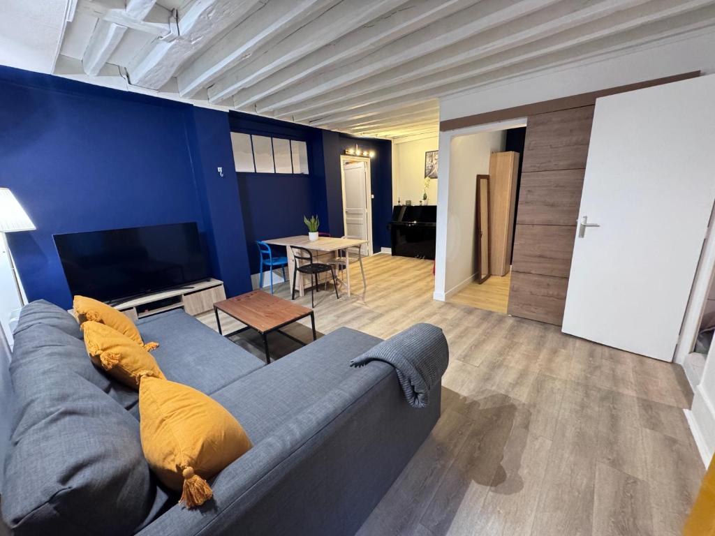 un salon avec un canapé bleu et une table dans l'établissement Flat in the center of Paris, à Paris