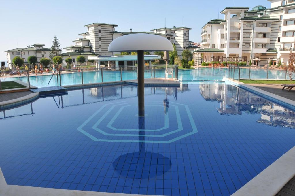 ラブダにあるKalina Private Apartments in Emerald Resort, Ravdaの水中の傘付きのスイミングプール