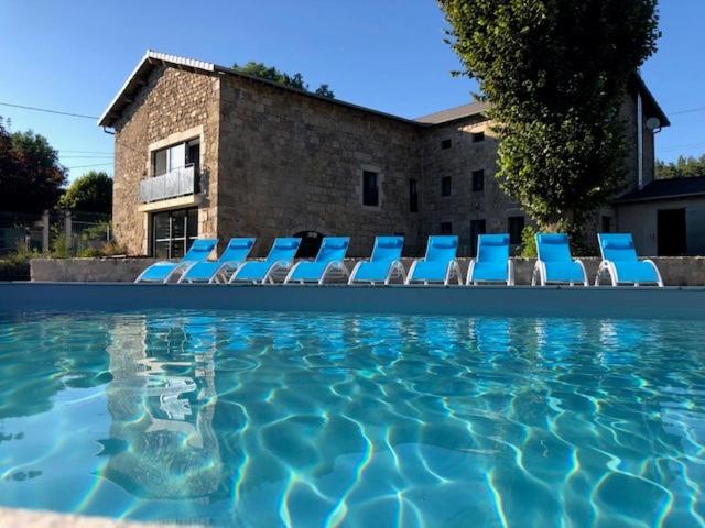 - un groupe de chaises bleues et une piscine dans l'établissement Le GIte de Lavalette, à Lapte