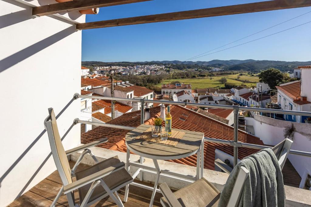 a balcony with a table and chairs and a view at Casa Azul - Aljezur Town in Aljezur