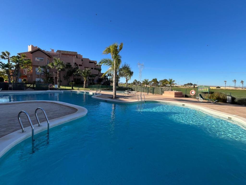 a large pool with blue water in a resort at Beautiful 2 Bed Apartment Mar Menor Golf Resort in Los Martínez