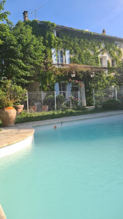 une grande piscine d'eau en face d'une maison dans l'établissement Le 140 du Ventoux, à Saint-Saturnin-lès-Avignon