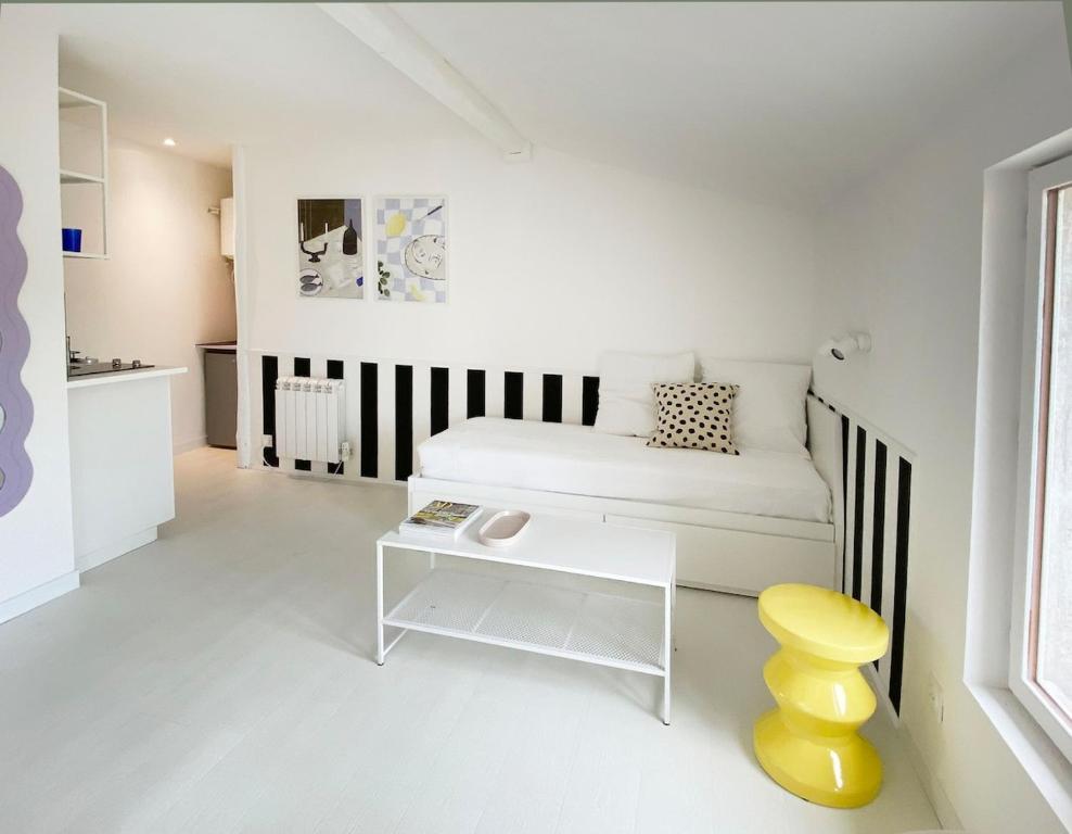 une chambre blanche avec un lit et une table dans l'établissement Joli studio vue sur Saône, à Caluire-et-Cuire