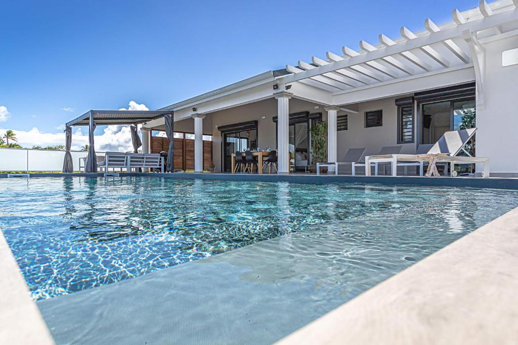 a swimming pool in front of a house at Villa Mélina in Capesterre-de-Marie-Galante
