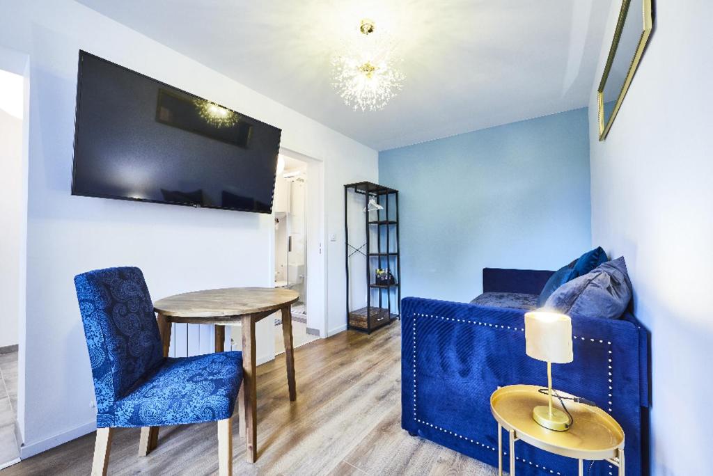 un salon avec un canapé bleu et une table dans l'établissement RBB 1G - Studio 1 à 2 personnes tout équipé 1er étage, à Mulhouse