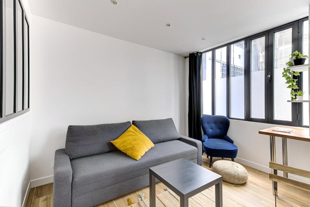 un salon avec un canapé et une chaise dans l'établissement 318 Suite Pivert - Superb apartment in Paris, à Paris