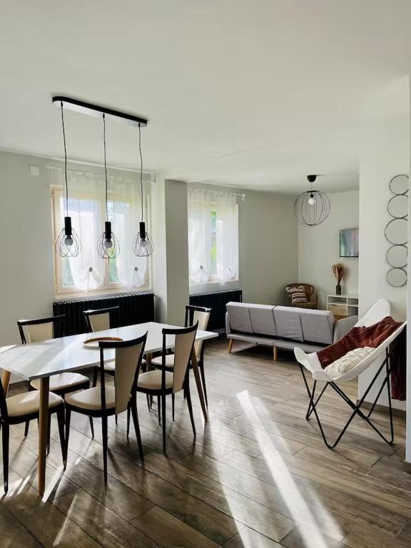 un salon avec une table, des chaises et un canapé dans l'établissement Chez Yvonne, à Neuf-Église