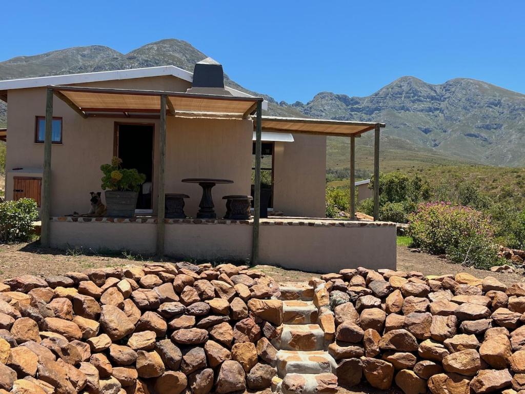ein Haus mit einer Steinmauer davor in der Unterkunft Renewal Retreat Klein Karoo Cottage in Uniondale