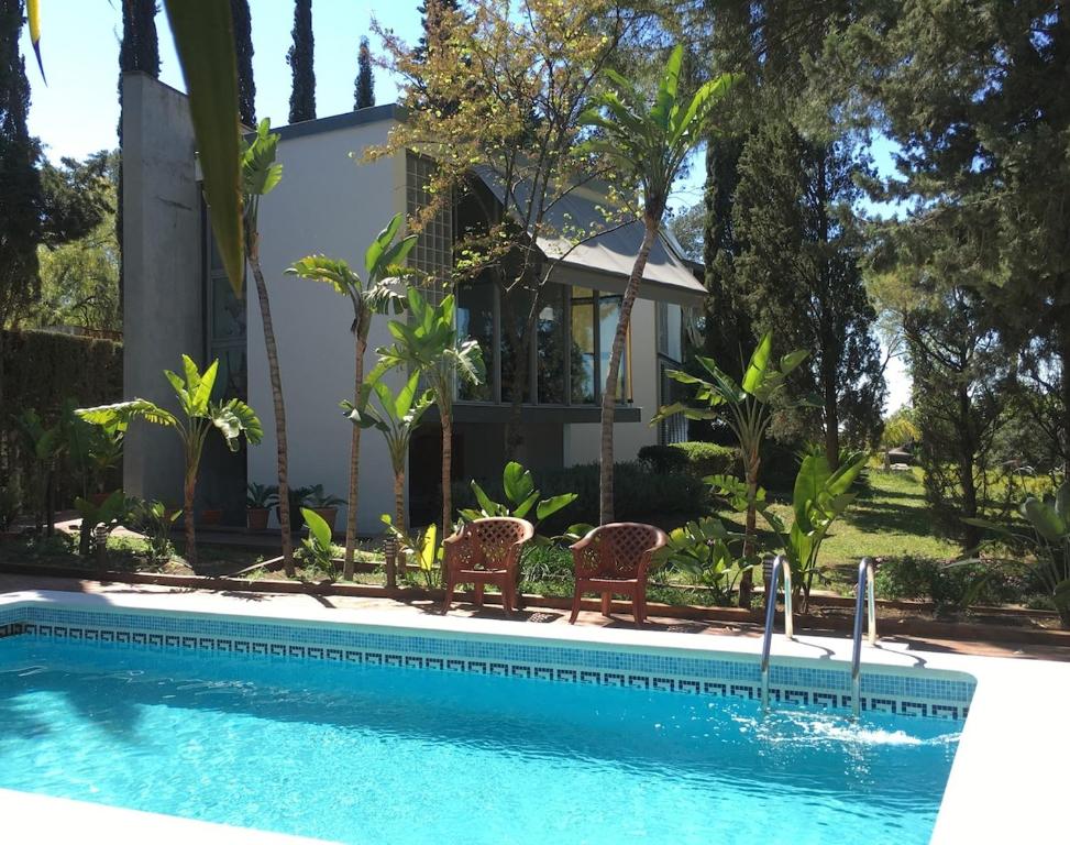 una casa con piscina delante de una casa en Loft surrounded by nature next to Seville with swimming pool and parking, en Espartinas