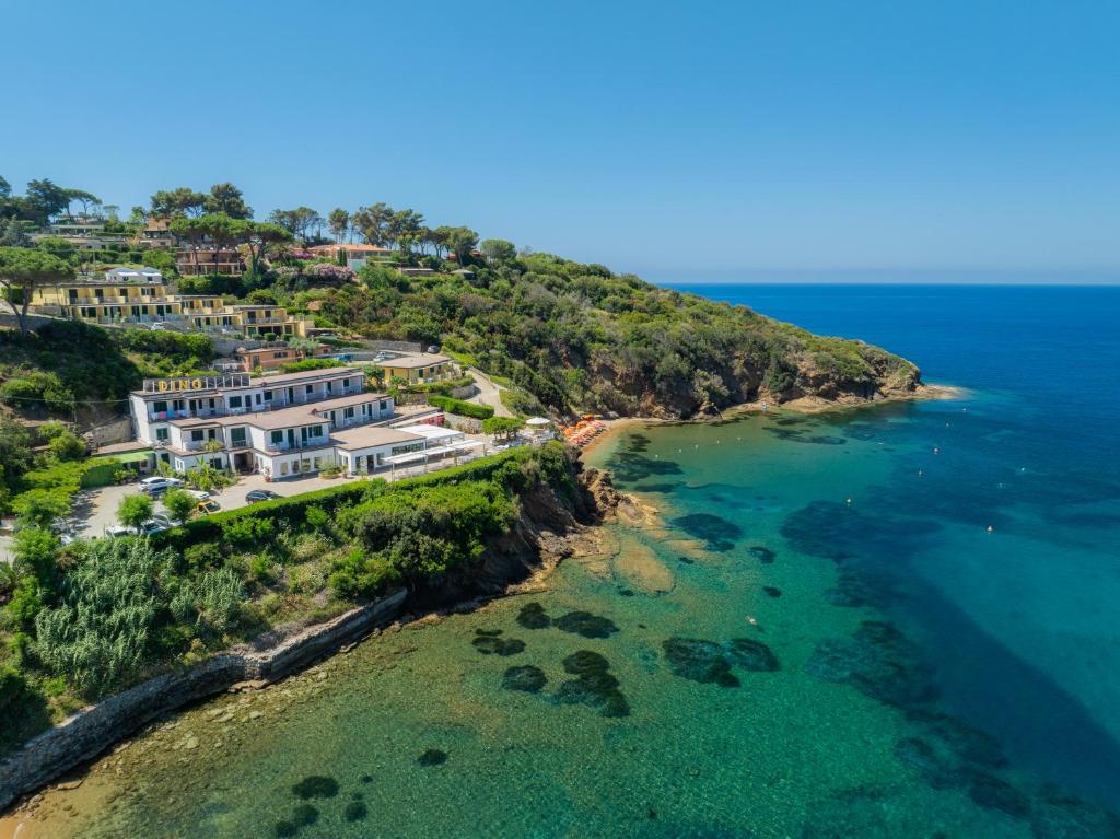 an aerial view of a house on a hill next to the ocean at Hotel Dino in Capoliveri