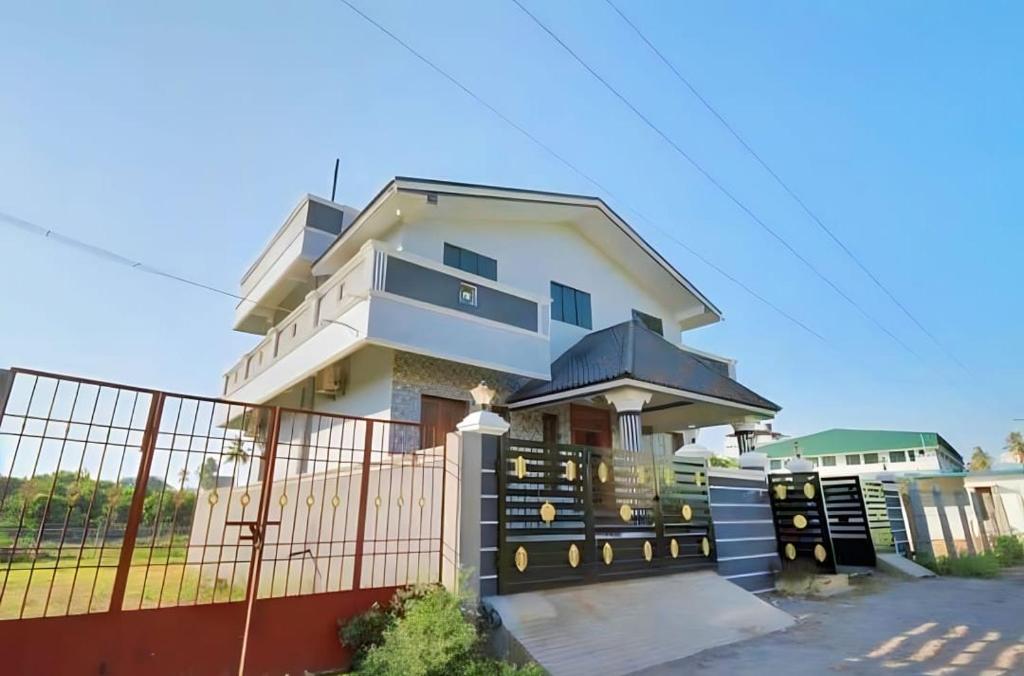 a large white house with a fence at Vintage Luxury Bungalow in Puducherry