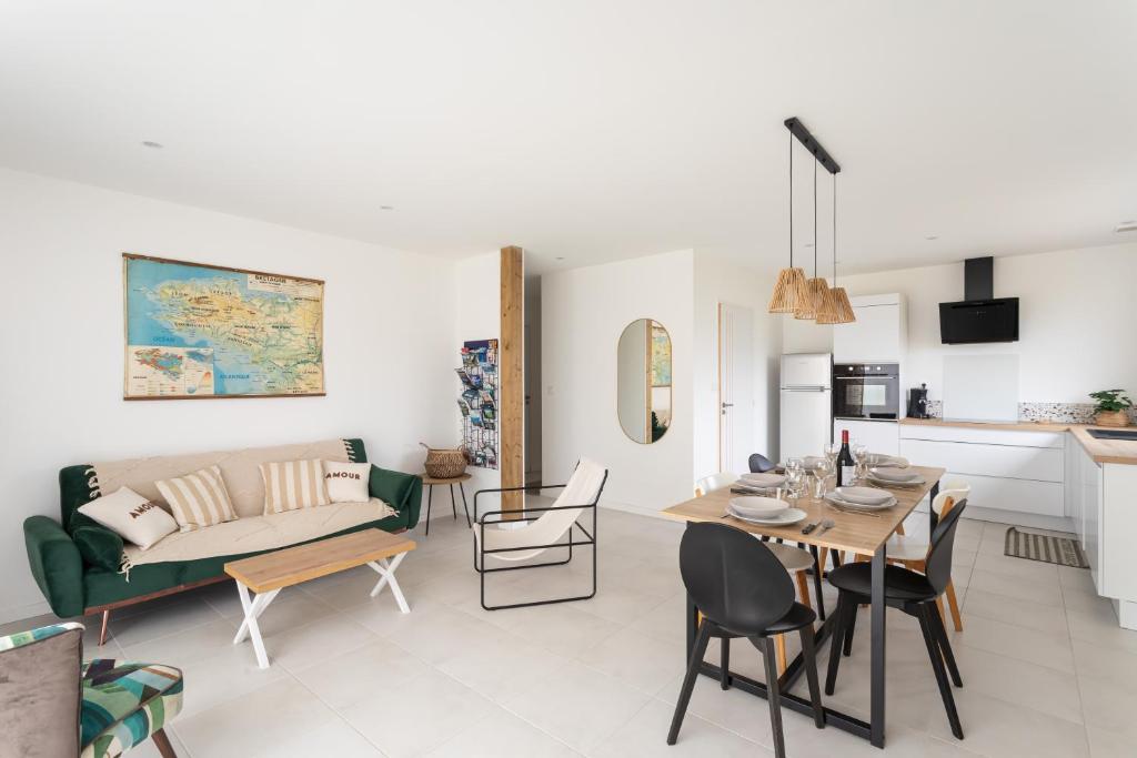 a living room with a table and a couch at La Belle de Fréhel - Jolie maison avec jardin in Frehel