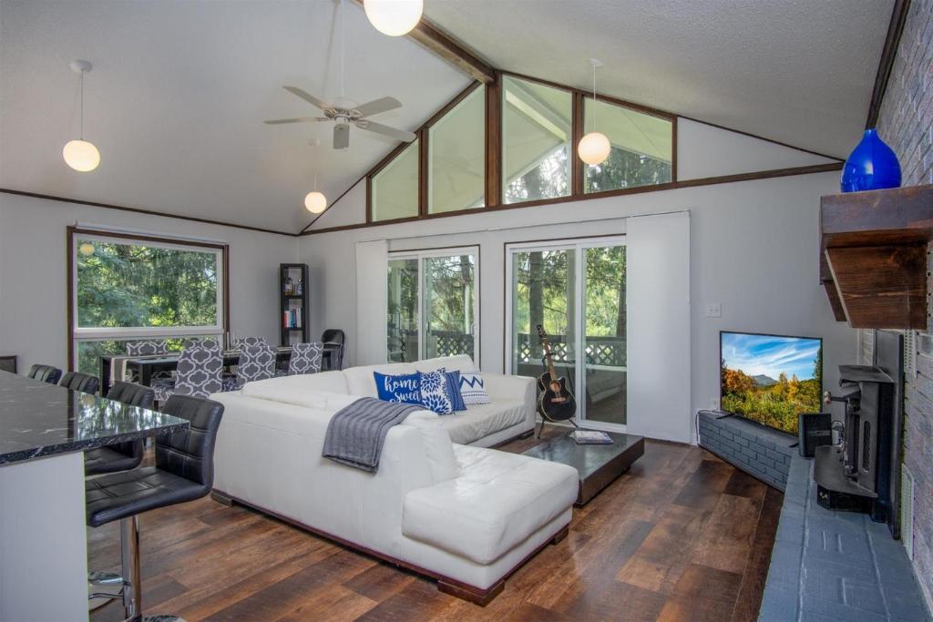 a living room with a white couch and a tv at Bass Lake Retreat in Pisgah Forest