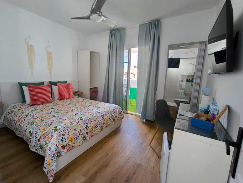 a bedroom with a bed with red pillows and a mirror at Paradise room near the beach in Playa Honda