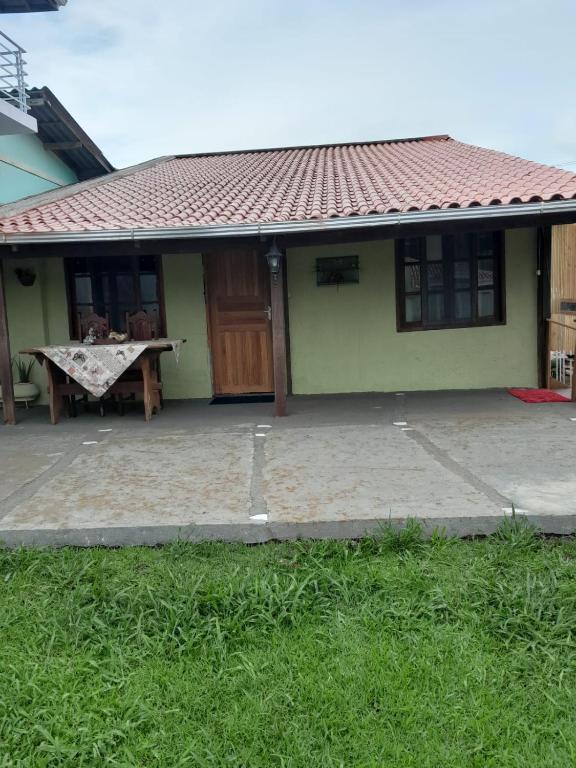 una pequeña casa con una mesa delante en Casa do arco-íris, en Florianópolis
